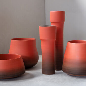 Distinguished Rina Menardi Steli vase sculpted from baked clay with a captivating gradient of reddish-brown tones and matte finish