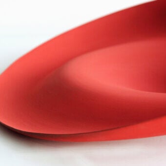 Exclusive Rina Menardi Trottole centerpiece crafted from baked clay with a vibrant red organically curved form and smooth matte finish