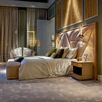 Sicis Casanova king bed, beige upholstery, petal-shaped headboard with amber lighting, paired with glossy nightstands in a gold-toned bedroom.