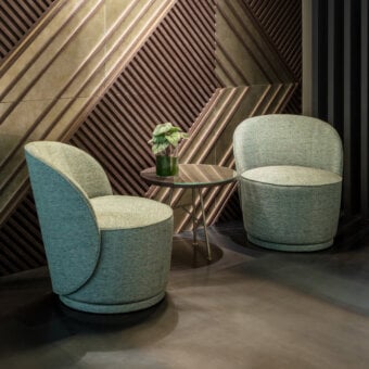 Elegant Sicis Celebrity lounge chair with muted grayish-blue-green textile upholstery and continuously rounded solid wood construction