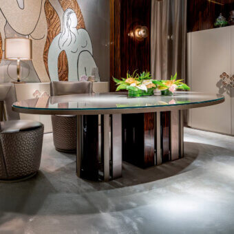Captivating Sicis Koro table with oval glass top and dynamic circular ebony and metal slat base with glossy finish