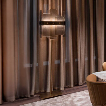 Sicis floor lamp, brushed brass finish, cylindrical stem with geometric stepped shade, black accent band, interior setting.
