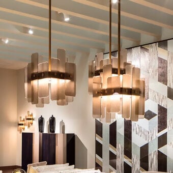 Sicis Oscar suspension lamps, translucent rectangular panels, brass rods, gray geometric tile wall, diffused warm light.
