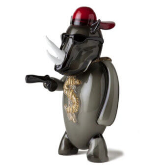 Gray Murano glass rhinoceros figurine with white horns, sunglasses, red cap, gold dragon design, and black handgun.
