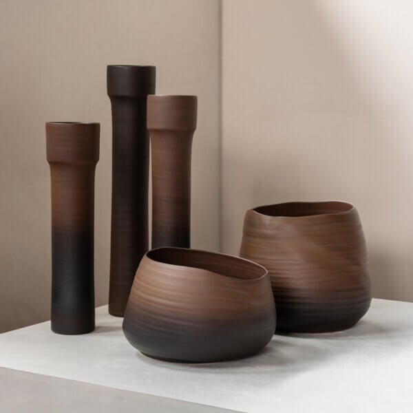 Ceramic vessels, handmade, brown tones, vertically striated, cylindrical vases, rounded bowl, asymmetrical gourd shape, matte finish.