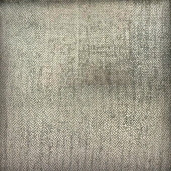 Herringbone textile, gray-green, dense weave with diagonal lines; faded central area shows mottled texture and tonal variations.