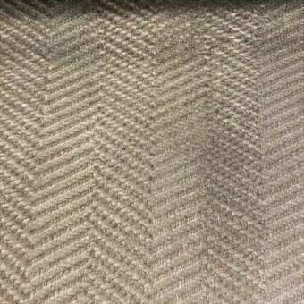 Herringbone textile sample in beige and taupe tones, displaying a dense weave with horizontal and diagonal thread structure, featuring label “cf1087 col. 2903”.
