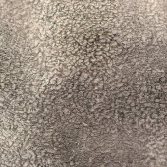 Gray looped pile fabric texture with a matted surface and short-cut loops, displaying mottled tonal variations and a nubby, durable appearance.
