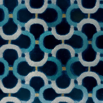 Geometric teal textile pattern with interlocking circles, navy accents, and gold threading, exhibiting a plush, slightly raised fabric texture.