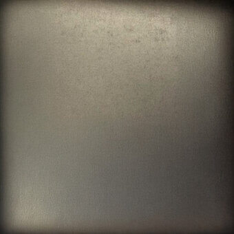 Gray textured surface with granular pattern, subtle gradient, and dark vignette framing, resembling distressed concrete or plaster.