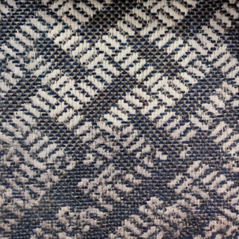 Textile sample with dark blue and off-white chevron weave, featuring a textured surface and muted navy-toned geometric pattern.