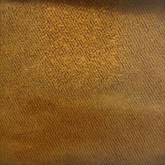 Fibrous texture sample in golden-brown, displaying a granular surface with diagonal ridges and matte finish, labeled “co1010 col. 612”.