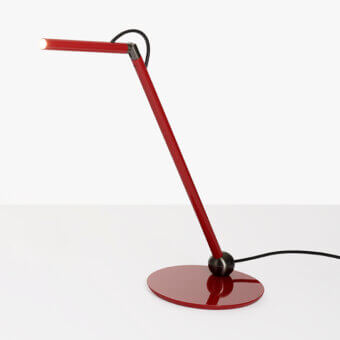 Scarlet red desk lamp with slender arm, circular base, adjustable gray joint, matte white head, and black power cord on white background.