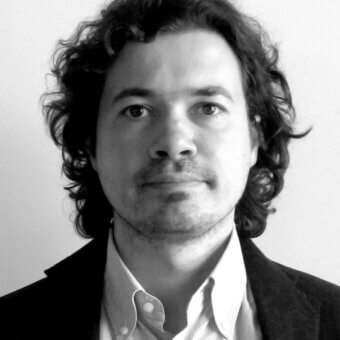 Black and white portrait of Paolo Imperatori, a man with dark wavy hair, mustache, and goatee, wearing a blazer and collared shirt.