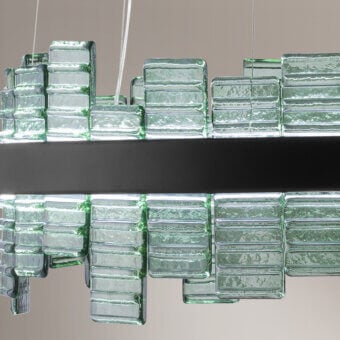 Suspension lamp, matte black metal, rectangular translucent green glass blocks with rippled texture in staggered, undulating rows.