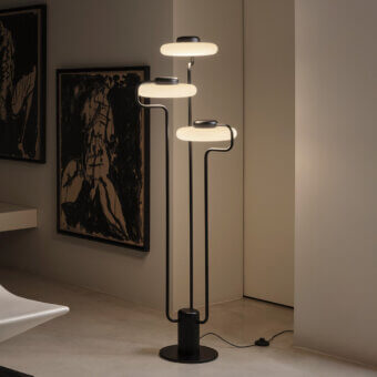 Distinguished Kundalini Tratto floor lamp crafted in metal and opal glass with a matte black finish and contemporary geometric loops
