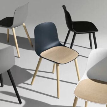 Elegant Lapalma Seela chair with aerodynamic design in navy blue molded plastic and light-toned wooden legs crafted with a smooth matte finish