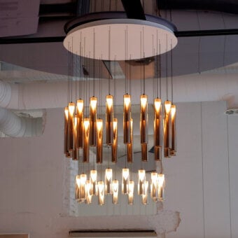 Exclusive Penta Iconica suspension lamp crafted in borosilicate glass with a warm coppery-bronze finish and matte aluminum canopy