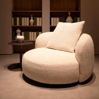 Exceptional Verzelloni Vic lounge chair upholstered in warm beige bouclé-like textile with iron swivel base