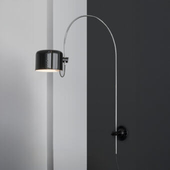 Superior Oluce Coupé wall lamp delivering directed light with a glossy silver-tone metal arm and black cylindrical lampshade with horizontal ridges