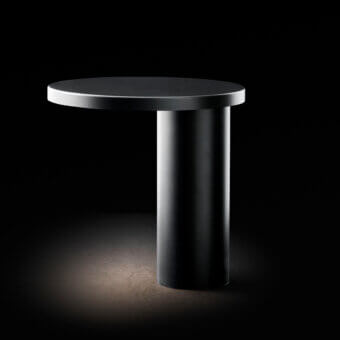Elegant Oluce Cylinda lamp crafted in dark metal with matte finish embodying minimalist geometric form and directed illumination