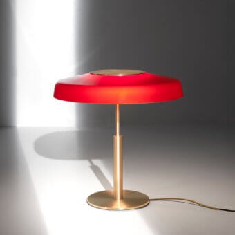 Distinguished Oluce Dora lamp embodies timeless Italian design with a red glass lampshade and polished metal stem