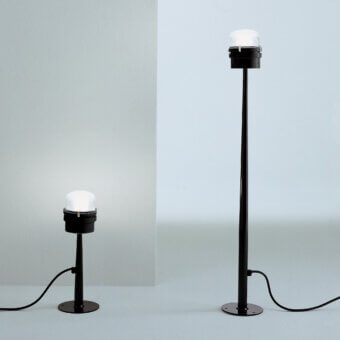 Distinguished Oluce Fresnel floor lamp with iconic lens and translucent white shades in matte black metal construction crafted in Italy