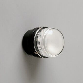 Distinguished Oluce Fresnel wall lamp crafted in matte black metal with a clear glass lens and subtle chrome accents
