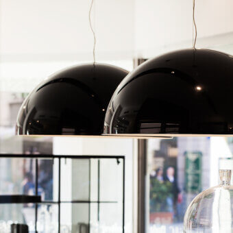 Elegant Oluce Sonora lamp suspension crafted in Italy with glossy black finish and harmonious spherical form