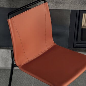 Sophisticated Bontempi Shape chair with angular form upholstered in smooth terracotta synthetic leather and black metal frame