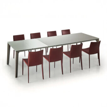 Extendable table, white marble top, dark gray angled legs, with six burgundy leather chairs, modern dining set, studio shot.