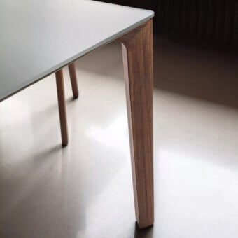 Bontempi Versus square table, matte white top, light wood tapered legs, studio shot, neutral gray floor, modern design.