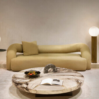 Distinguished Rugiano Abbraccio sofa with low curved form upholstered in warm beige fabric and bronzed brass details