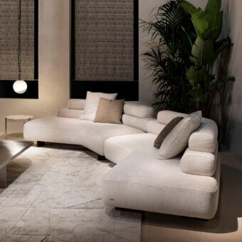 Exceptional Rugiano Bali sectional with plush cylindrical cushions upholstered in textured woven beige fabric with bronzed brass details
