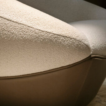 Exceptional Rugiano Iside lounge chair with uniquely faceted silhouette and cream textured fabric with brown leather base