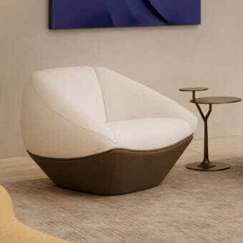 Captivating Rugiano Iside lounge chair with uniquely faceted form upholstered in textured light beige bouclé and dark brown premium leather base