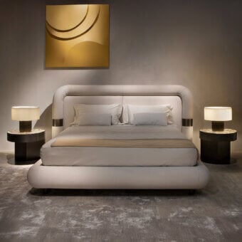 Distinguished Rugiano Loom bed with a continuously curved headboard upholstered in premium fabric and subtle Bronzed Brass detailing