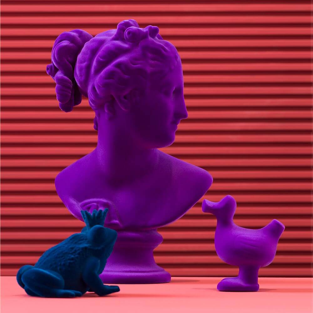 Cassoni Adriani Rossi Venus Italica velvet sculpture, purple bust with teal frog & duck on pink surface, red lined backdrop.
