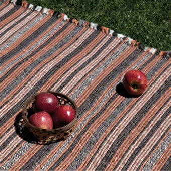 Distinctive Amini Prune rug with contemporary striped design in charcoal and coral recycled PET, finished with hand-clipped texture