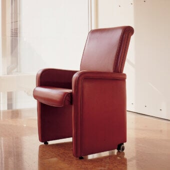 Distinguished Mascheroni Ypsilon V armchair upholstered in reddish-brown ox leather with seamless armrests and small back castors