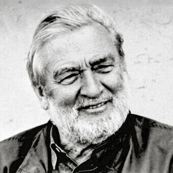 Verner Panton portrait, black and white photograph, showing a smiling man with white hair and beard, wearing a plaid jacket.