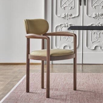 Distinguished Porada Dione chair reimagines a bucket seat with canaletta walnut and olive-green upholstery in a satin finish
