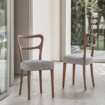Distinguished Porada Noemi chair with solid Canaletta walnut frame and subtly textured light gray fabric upholstery