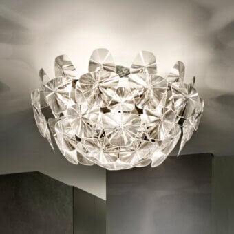 Elegant Luceplan Hope ceiling lamp crafted in transparent polycarbonate with a polished stainless-steel frame exhibiting captivating illumination