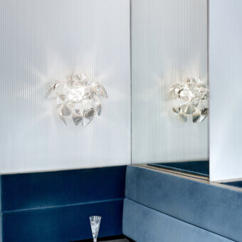 Superior Luceplan Hope Wall Lamp with a polished stainless-steel frame and transparent polycarbonate lenses creating sparkling light diffusion