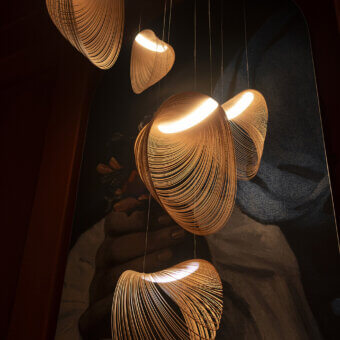 Elegant Luceplan Illan suspension lamp crafted in layered plywood with a satin finish and warm glow