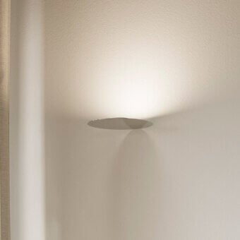 Elegant Luceplan Millimetro wall lamp with mirror-finish metal and a low-profile light gray aesthetic delivers warm illumination