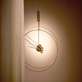 Distinguished Nomon Daro wall clock with gracefully curved metalwork and satin finish creating a light, balanced presence