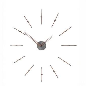 Superior Nomon Mini Merlín wall clock with slender dark bronze metal time signals and a light beige face