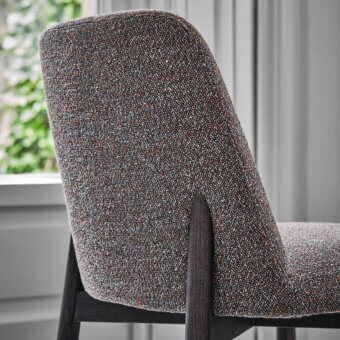 Distinguished Porada Abby chair with a gracefully curved Canaletto walnut frame and softly contoured seat upholstered in muted gray textile with satin finish